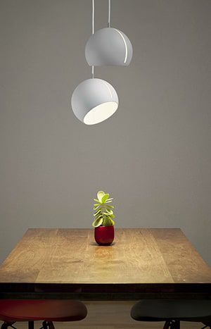 White globe pendant lights over table.