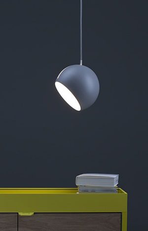Gray globe pendant lamp hanging over table.