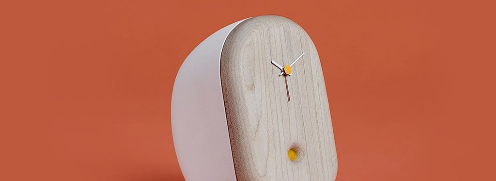 Wooden clock with white hands on orange background.