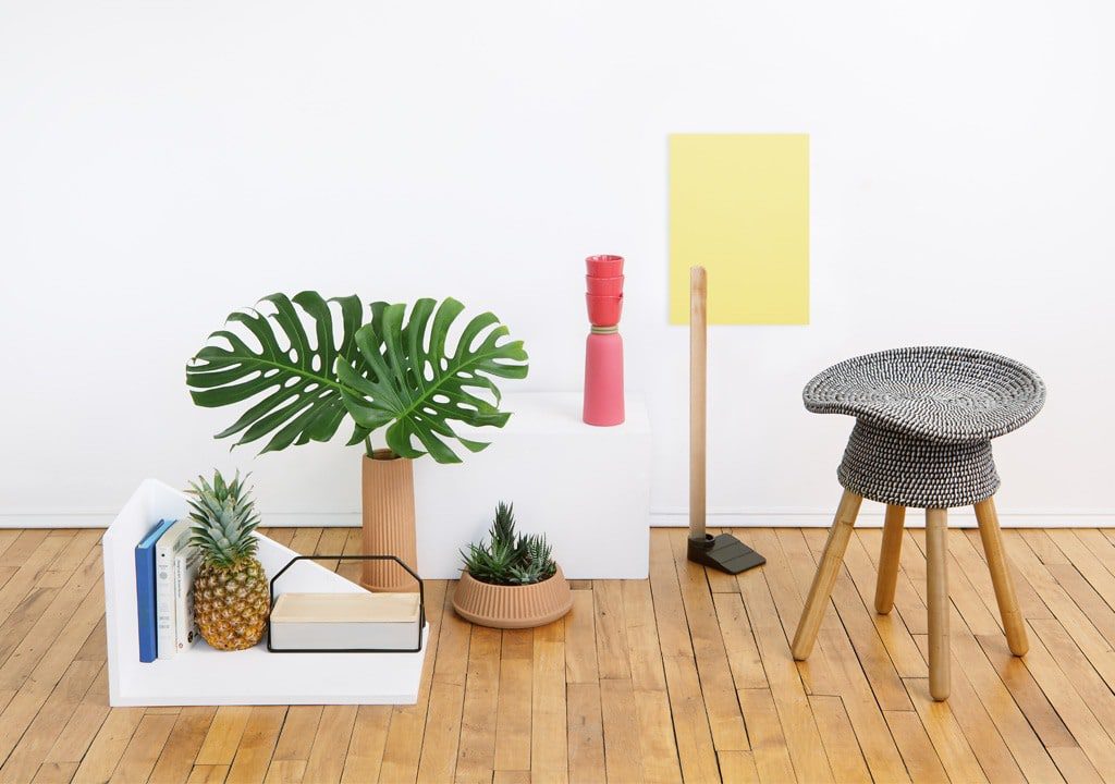 Minimalist interior with plants and a stool.