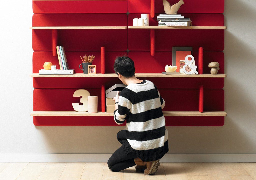 Person organizing shelves with red backing.