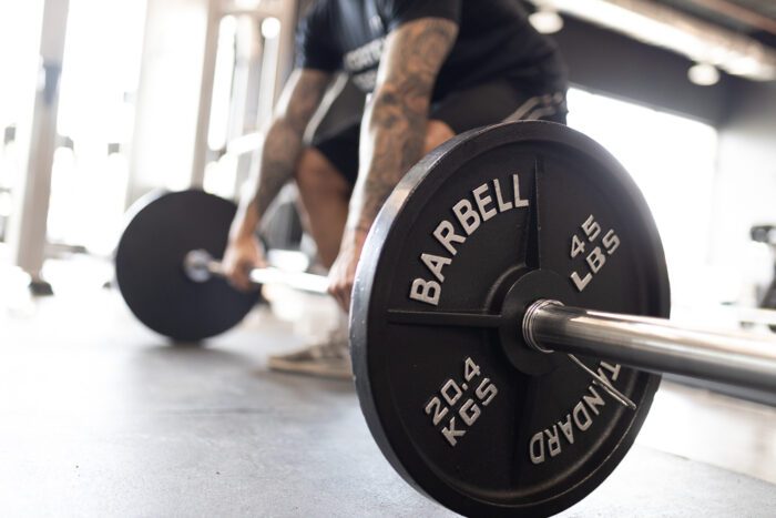 Black weight plate with 45 lbs barbell.