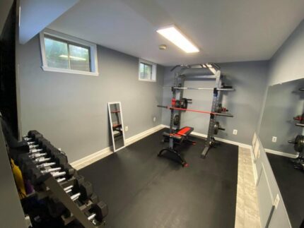 Home gym with weight rack and bench.