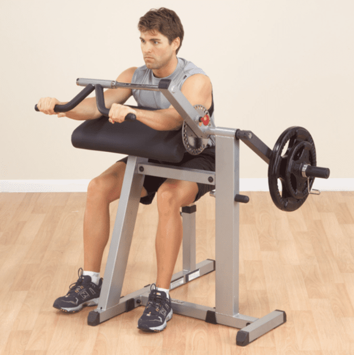 Man using an arm curl machine.