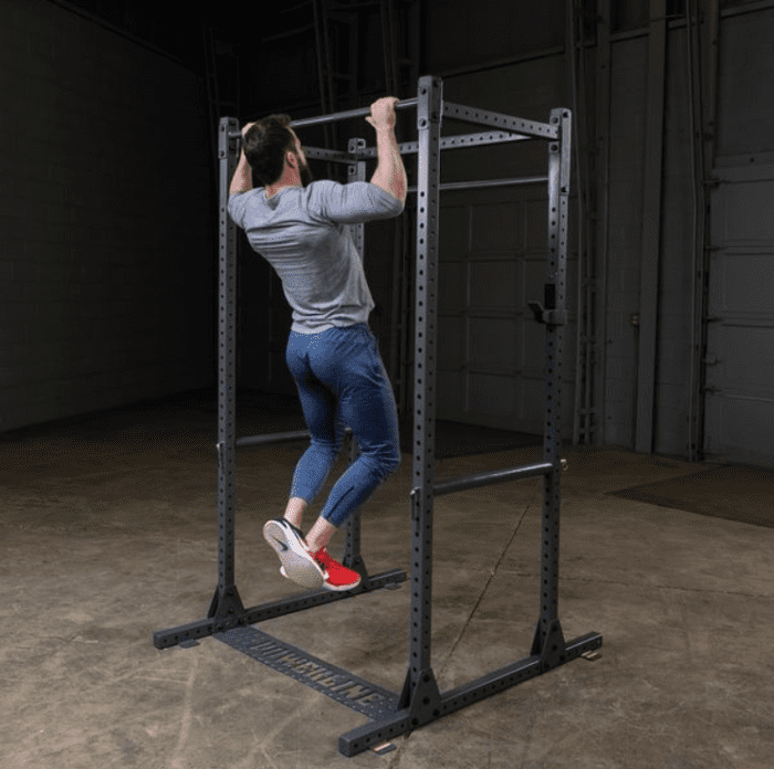 Man doing pull-ups on a gym rack.