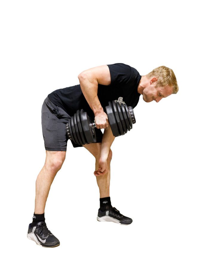 Man lifting adjustable dumbbells during workout.