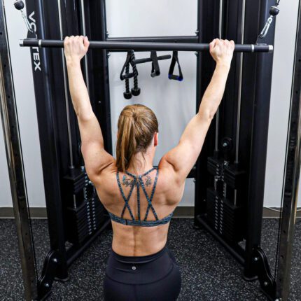 Woman doing lat pulldown exercise in gym.