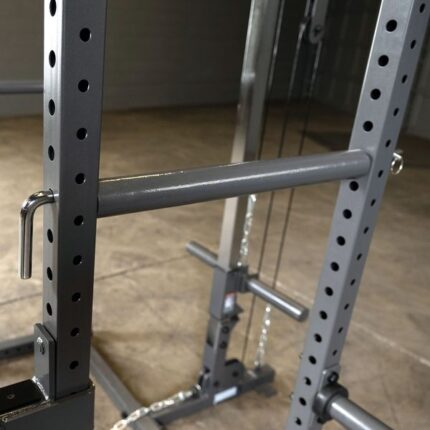 Gray metal weight lifting rack with safety bars.