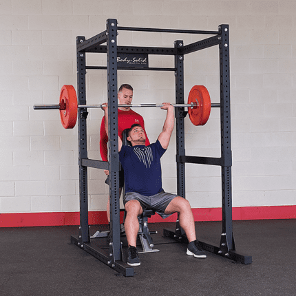 Man lifting weights in a squat rack.