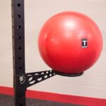 Red exercise ball on a gym rack.