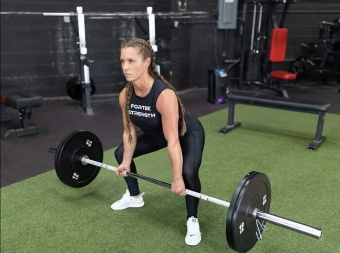 Woman lifting weights in a gym.