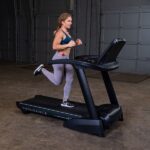 Woman running on a black treadmill.