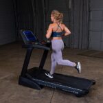 Woman running on black treadmill.
