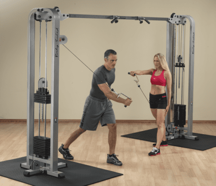 Two people using a Body-Solid cable machine.