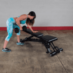 Woman lifting weights on a bench.