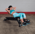Woman doing sit-ups on a weight bench.