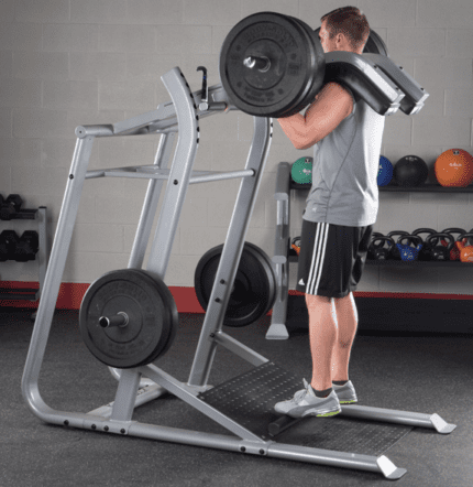 Man doing a seated calf raise on a machine.