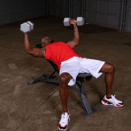 Man doing bench press with dumbbells.