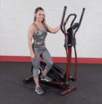 Woman exercising on a red elliptical machine.