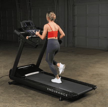 Woman running on a black treadmill.