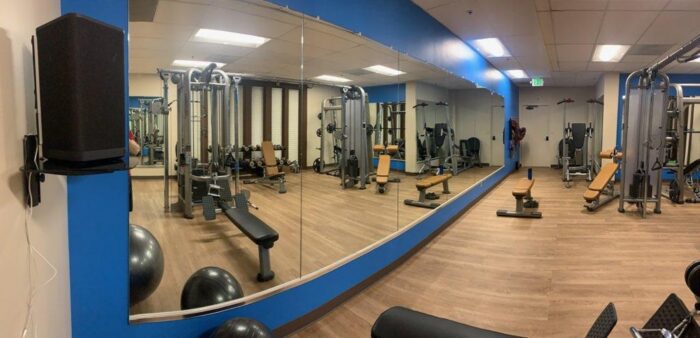 Gym with weight machines and mirrors.