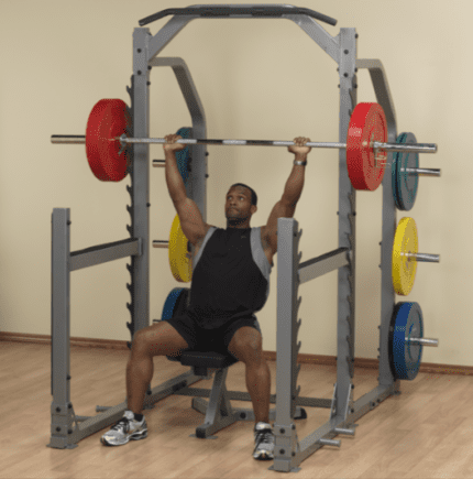 Man lifting weights in a squat rack.