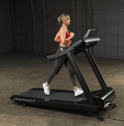 Woman running on a black treadmill.