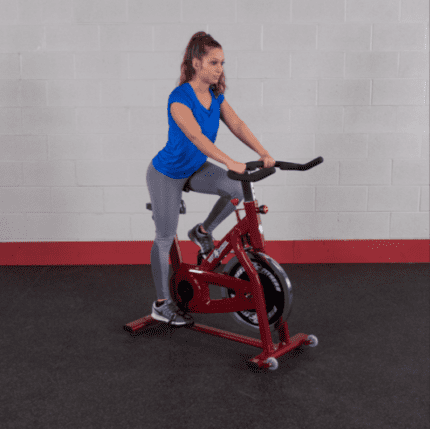 Woman exercising on a red spin bike.