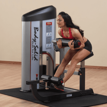 Woman using a Body-Solid gym machine.