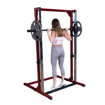 Woman lifting weights in a squat rack.