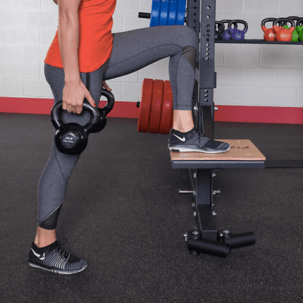 Woman lifting kettlebells in gym.