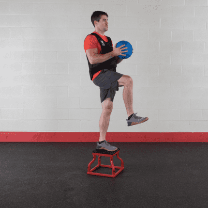 Man in weighted vest stepping on box.