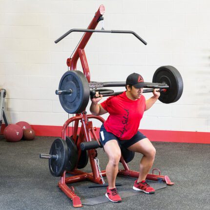 Man performing squat with weight machine.