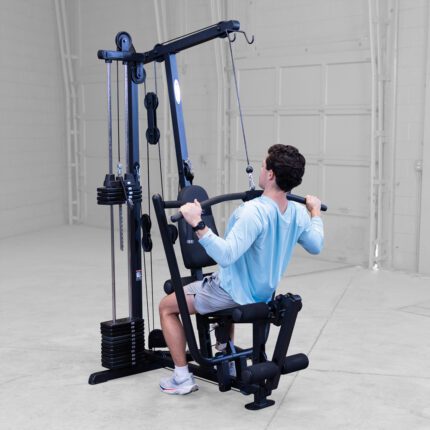 Person using lat pulldown exercise machine.