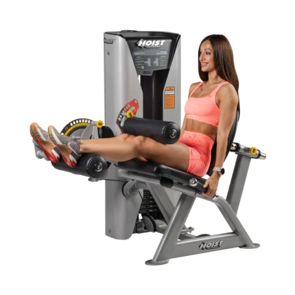 Woman using leg extension exercise machine.