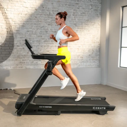 Woman jogging on a treadmill indoors.