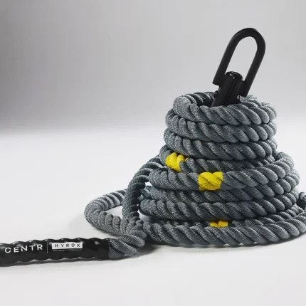 Coiled fitness rope with black handle.