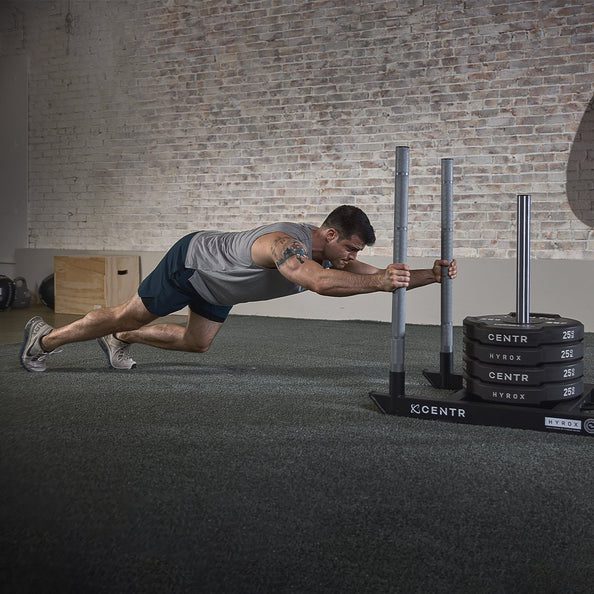 Man pushing weighted sled in gym. Man pushing weighted sled in gym.