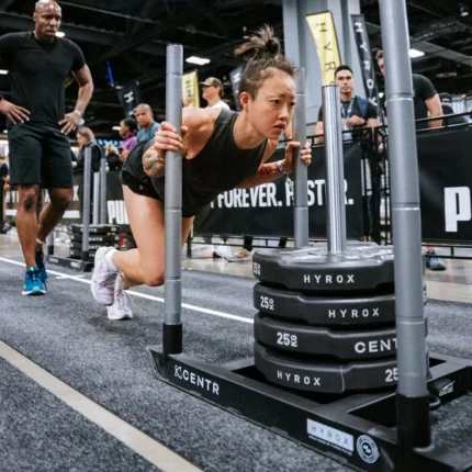 Person pushing weighted sled during competition.