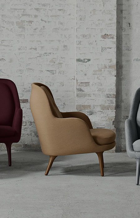 Tan armchair with wooden legs in room.