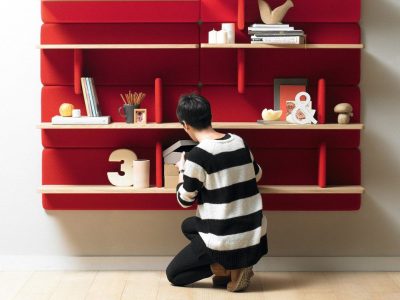 Person organizing shelves with red backing.